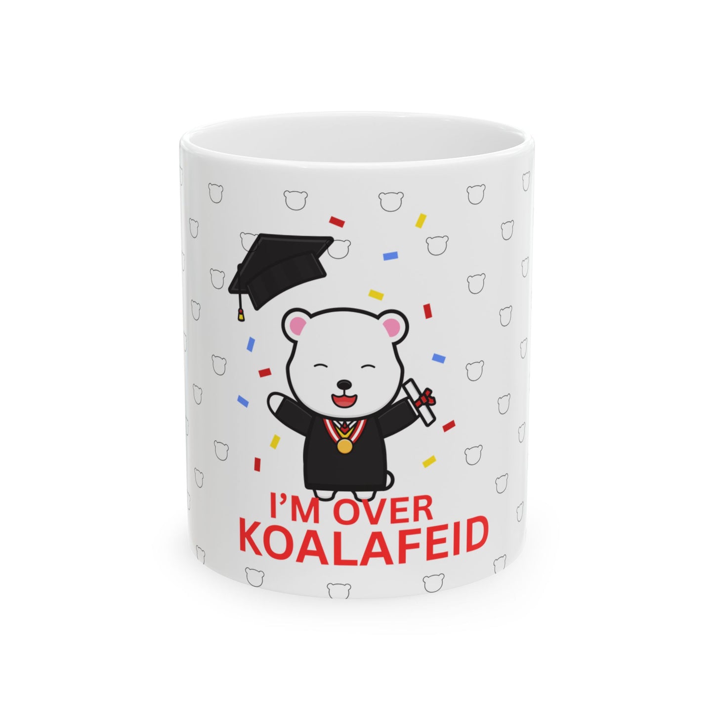 A white ceramic mug with a cartoon bear wearing a graduation cap and the text 'I'M OVER KOALAIED' on it.