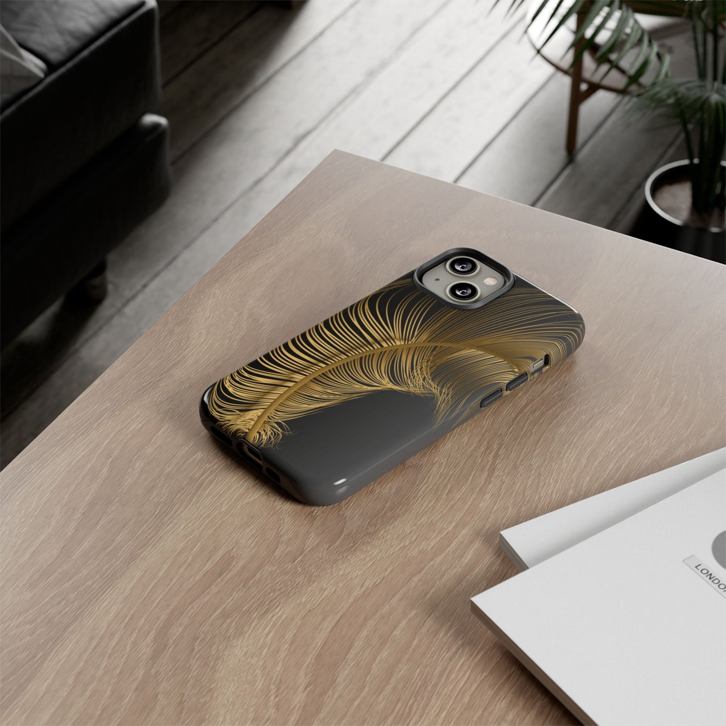 Phone case with gold feather design on black background