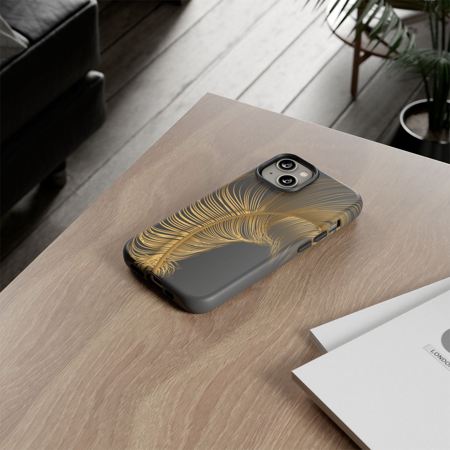 Phone case with gold feather design on black background