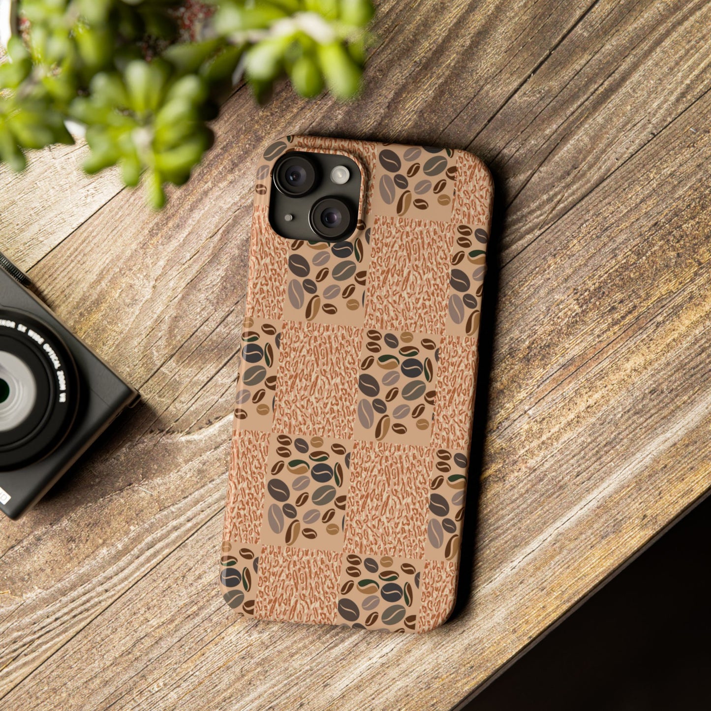 Phone case with coffee bean pattern on wooden surface.