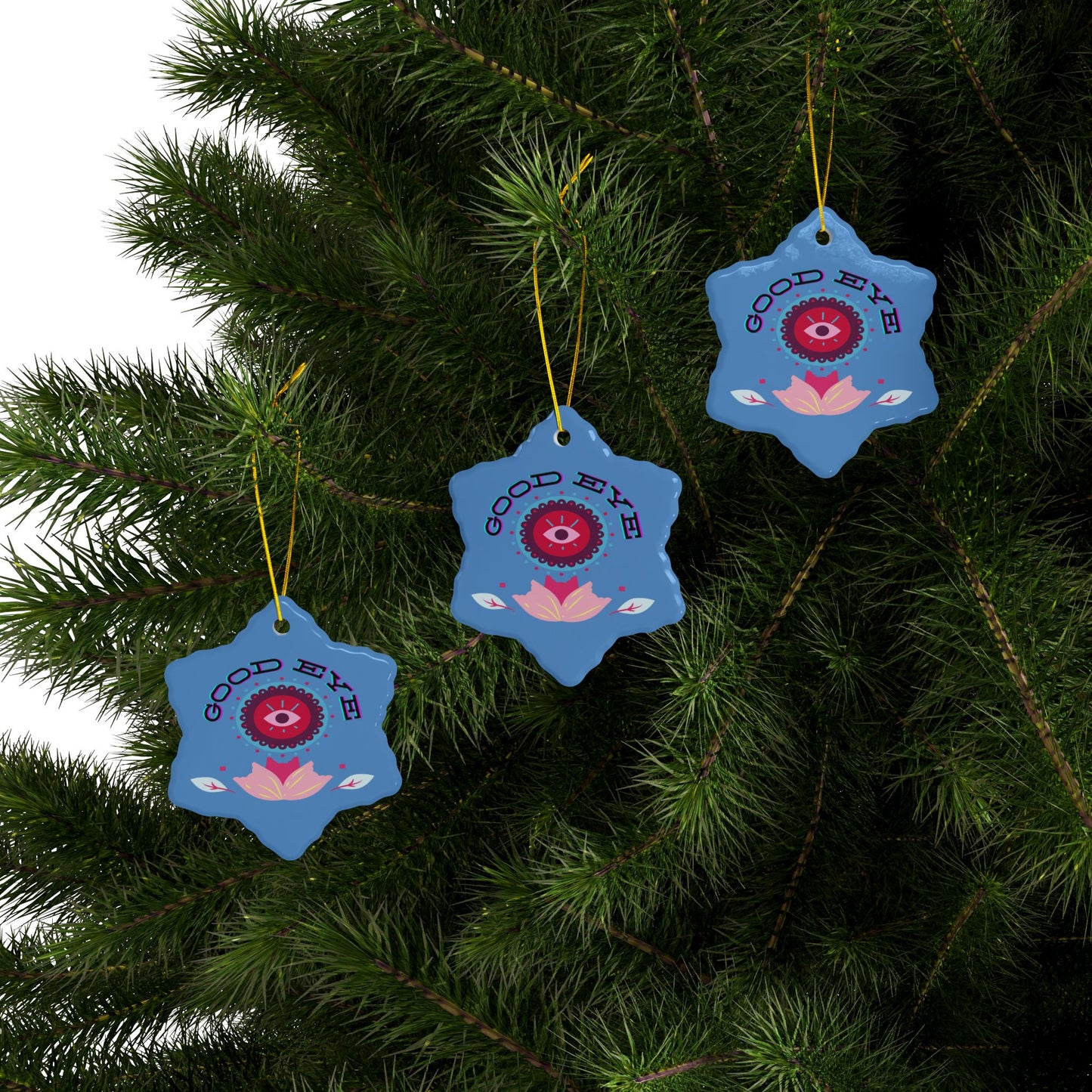 Blue decorative ornaments with red and pink designs on a Christmas tree.
