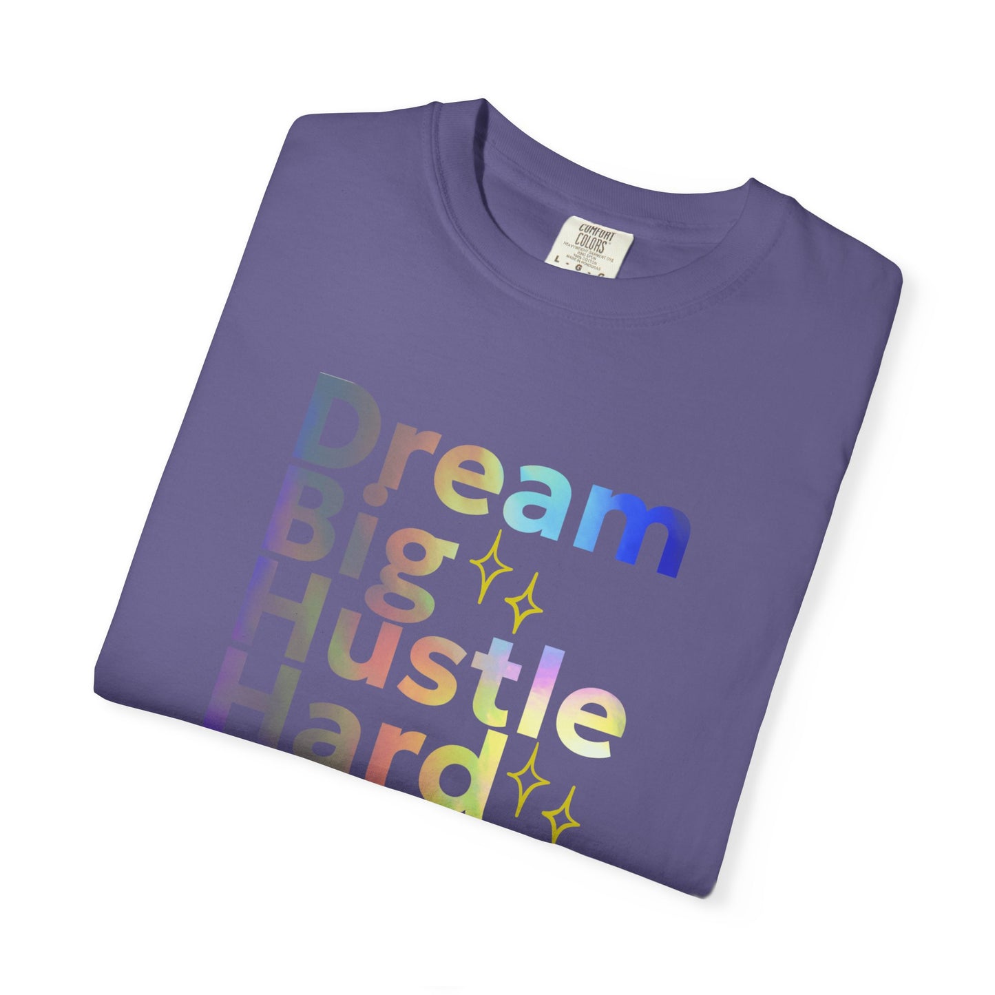Folded purple t-shirt with motivational text 'Dream Big Hustle Hard' on a white background