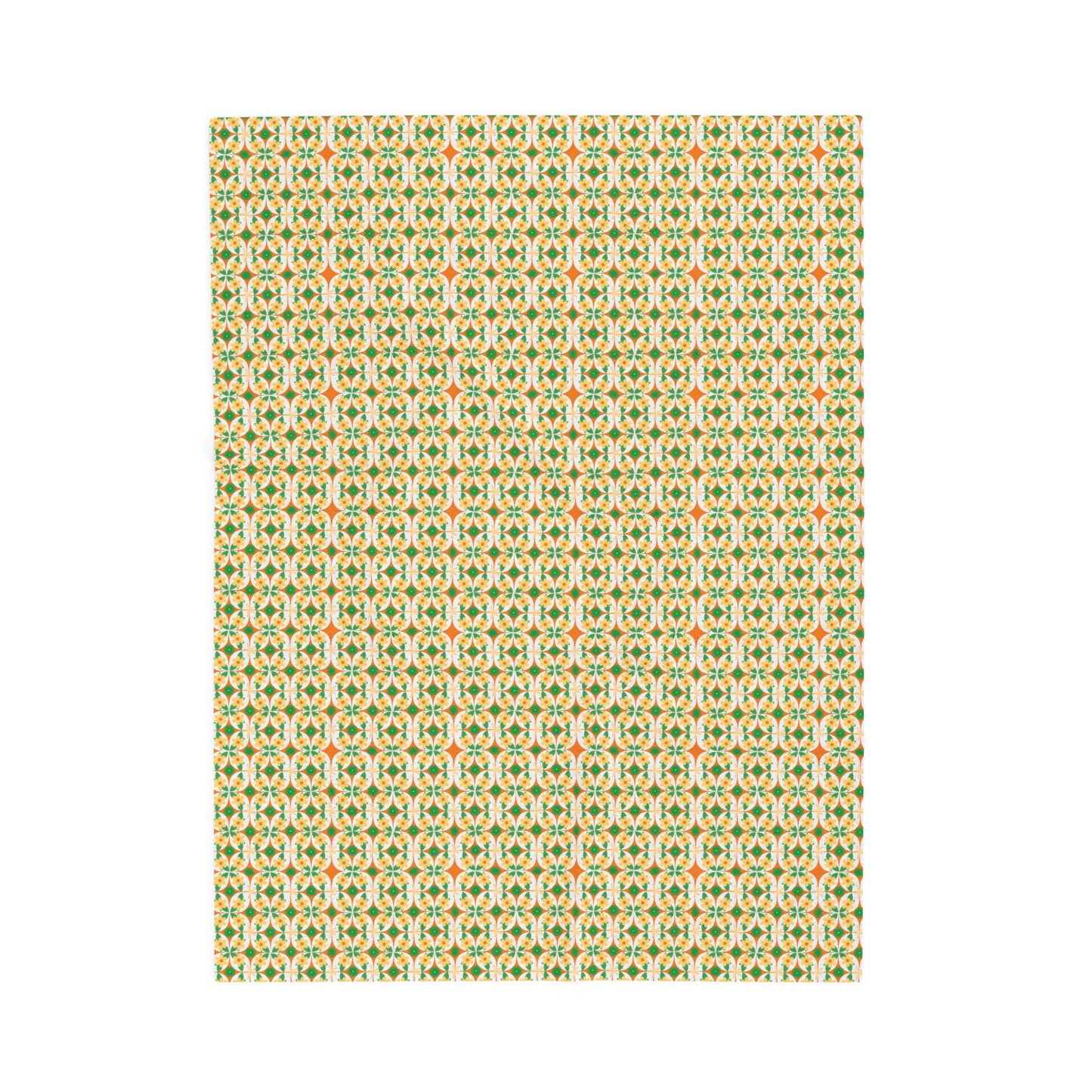 A folded velveteen plush blanket with a geometric pattern in green, yellow, and red colors.