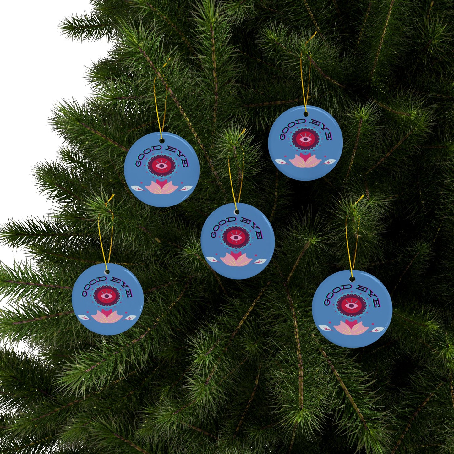 Blue decorative ornaments with red eye design hanging on a tree.