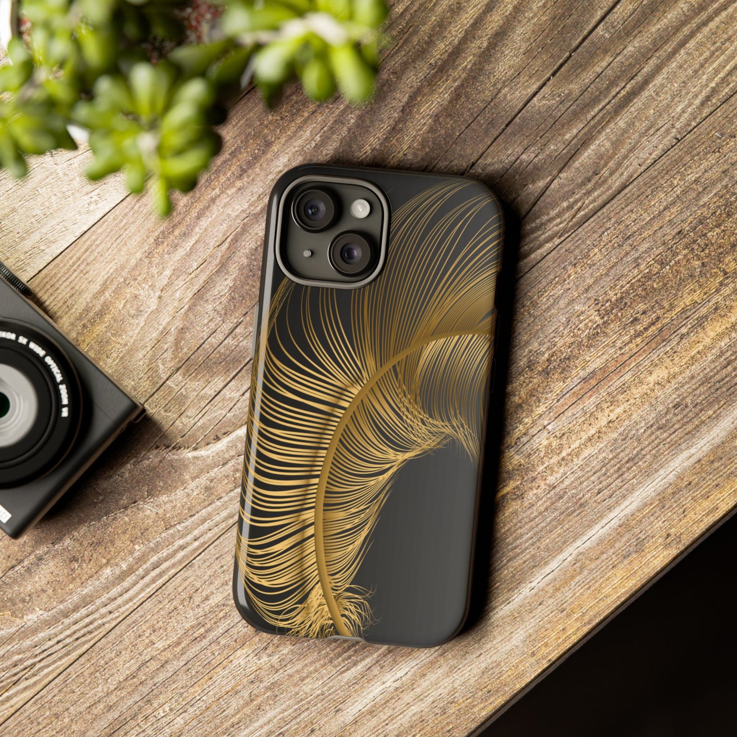 Phone case with gold feather design on black background