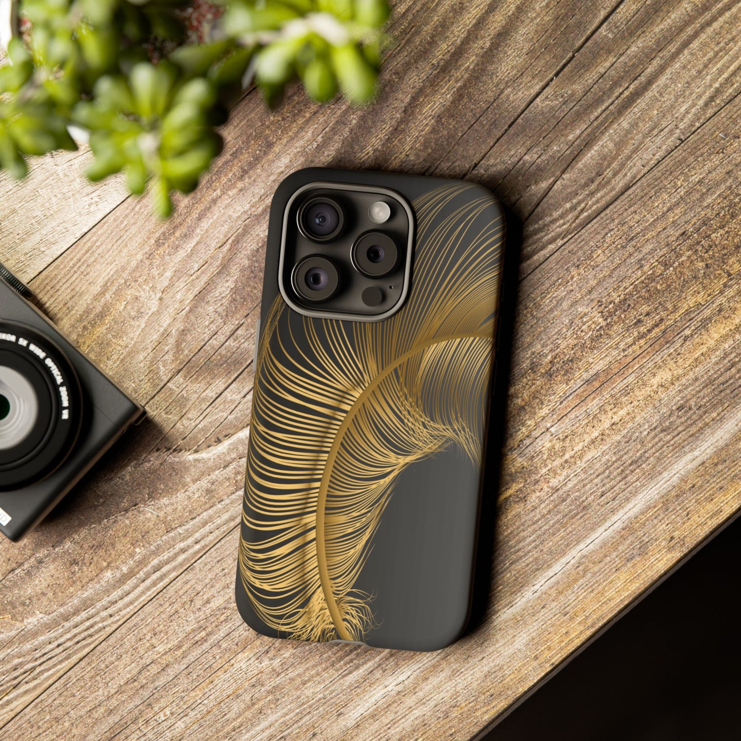 Phone case with gold feather design on black background