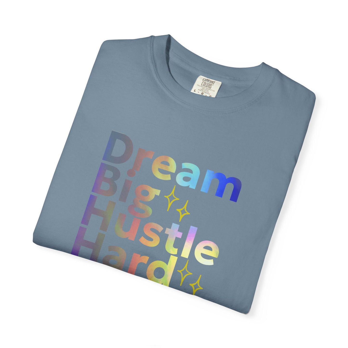Folded blue t-shirt with colorful text 'Dream Big Hustle Hard' on a white background
