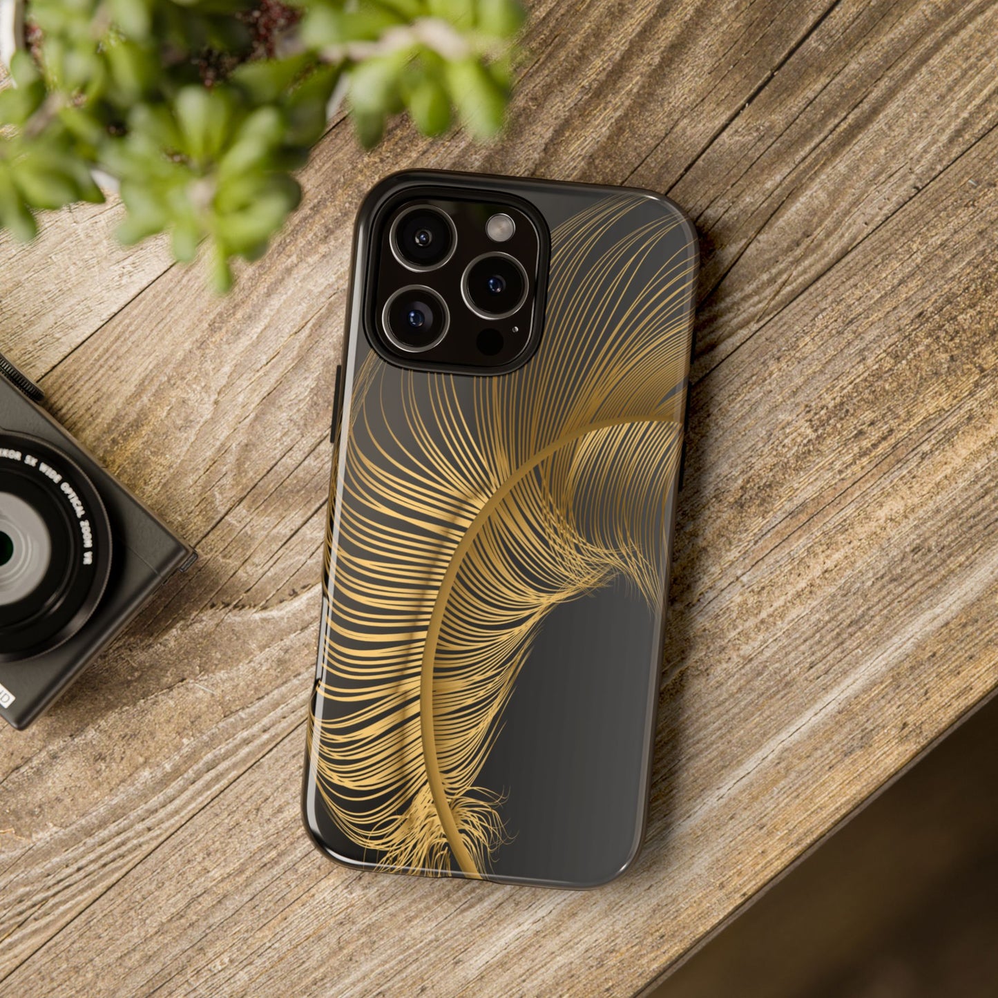 Phone case with gold feather design on black background