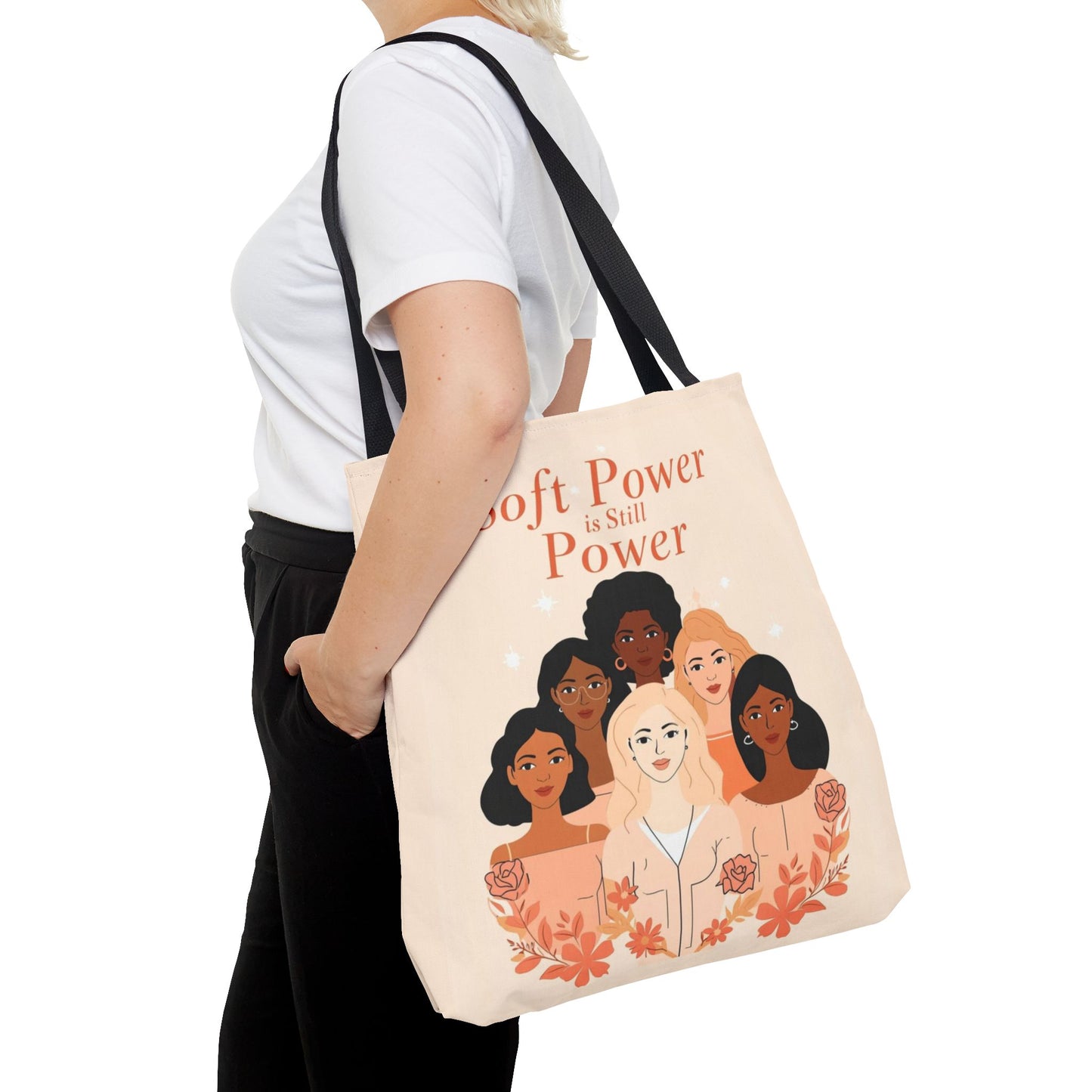 Tote bag with illustrations of diverse women and text, held by a person.