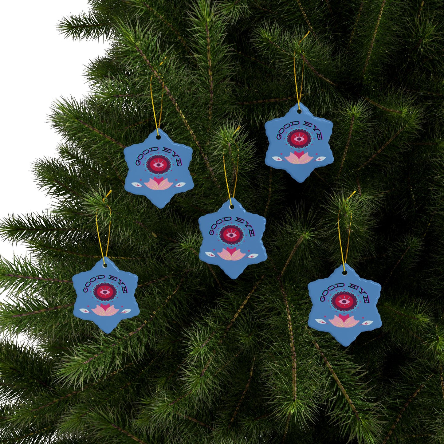 Blue decorative ornaments with red eye design hanging on a tree.