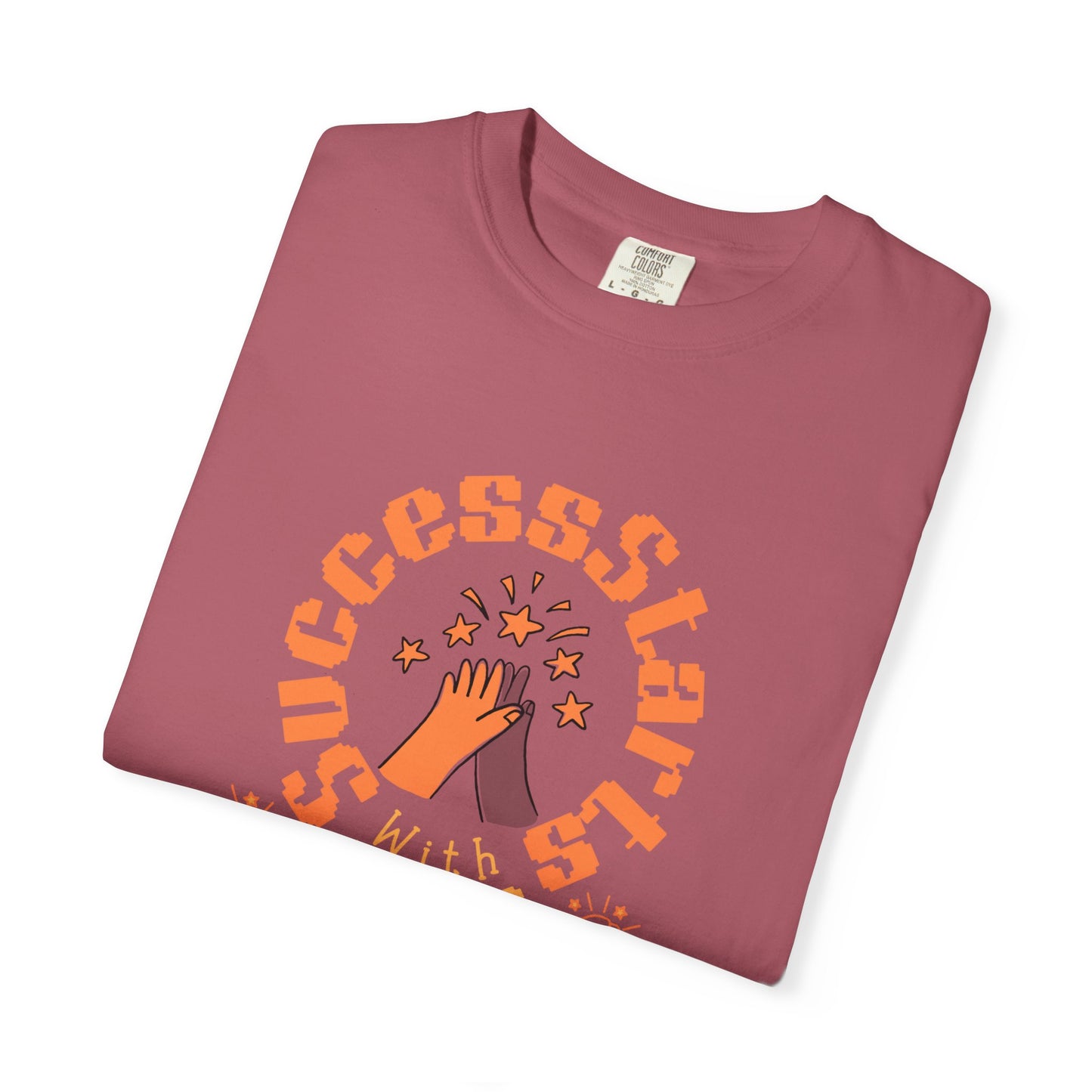 Folded maroon t-shirt with orange text and graphic on a white background