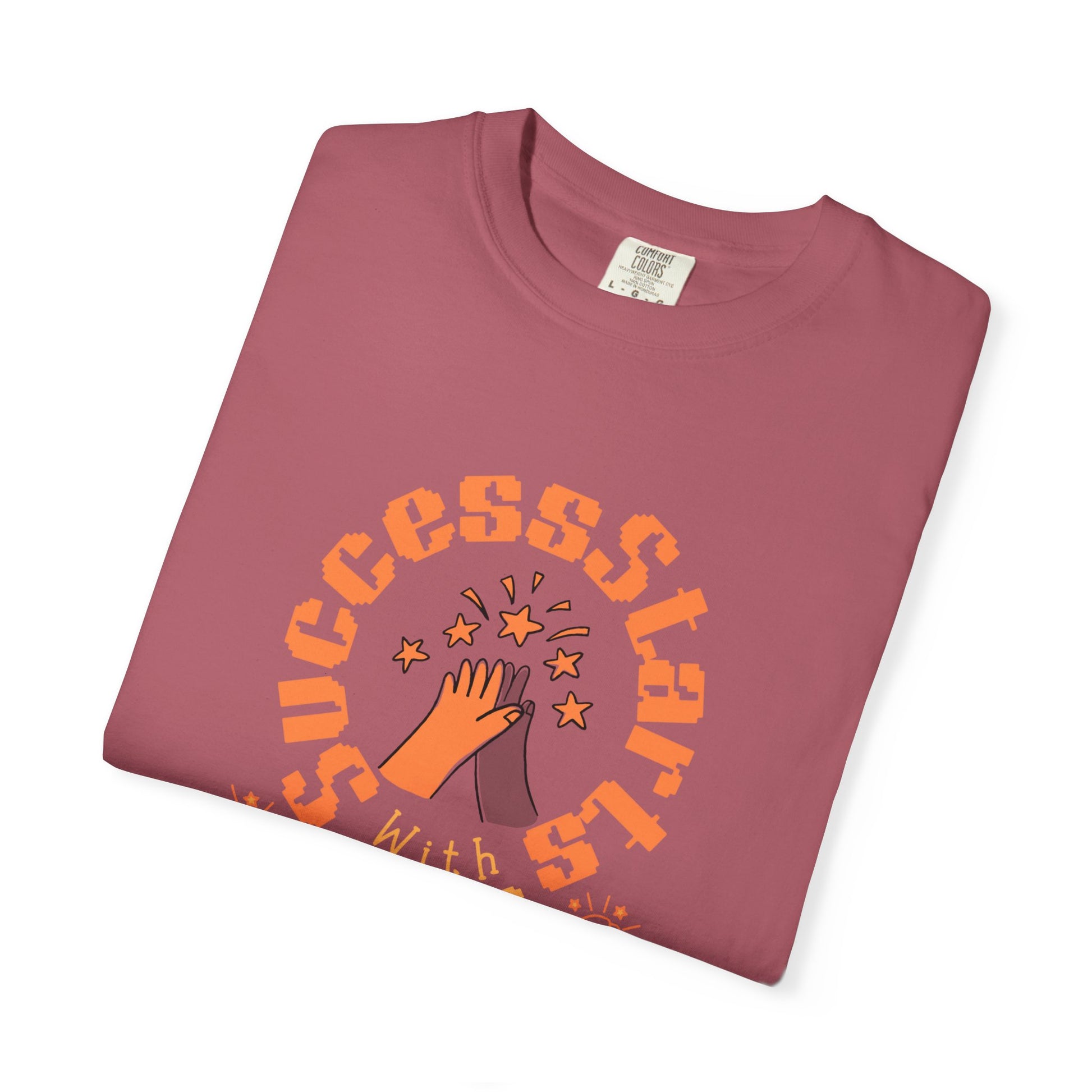 Folded maroon t-shirt with orange text and graphic on a white background