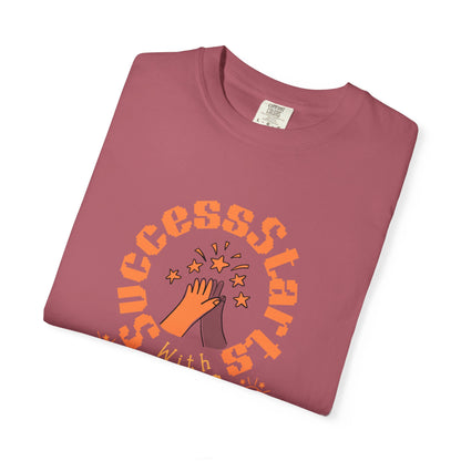 Folded maroon t-shirt with orange text and graphic on a white background