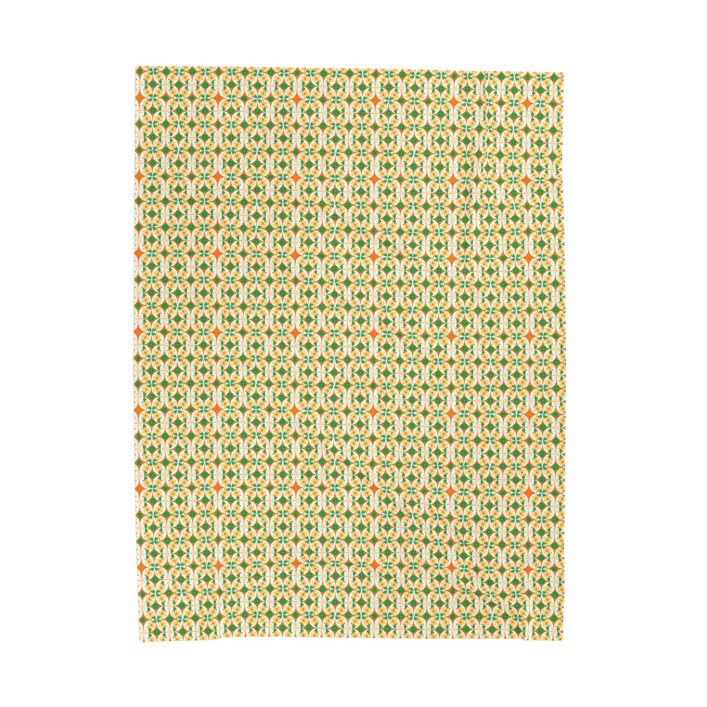 A folded velveteen plush blanket with a geometric pattern in green, yellow, and red colors.