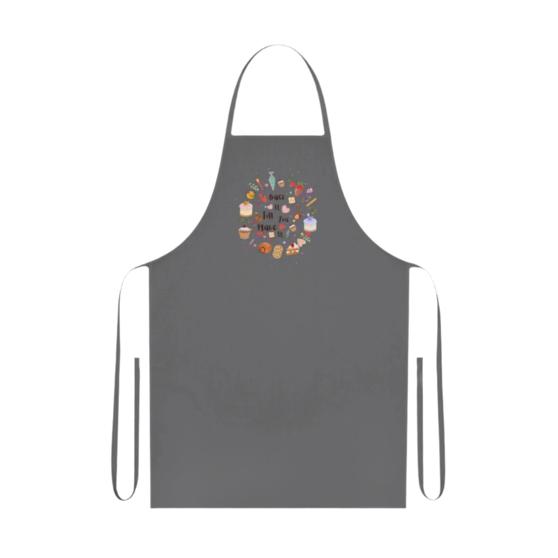 Cotton kitchen apron with "Bake it till you make it" text and circular illustrations of cake, biscuit, cone, and baking utensils.

