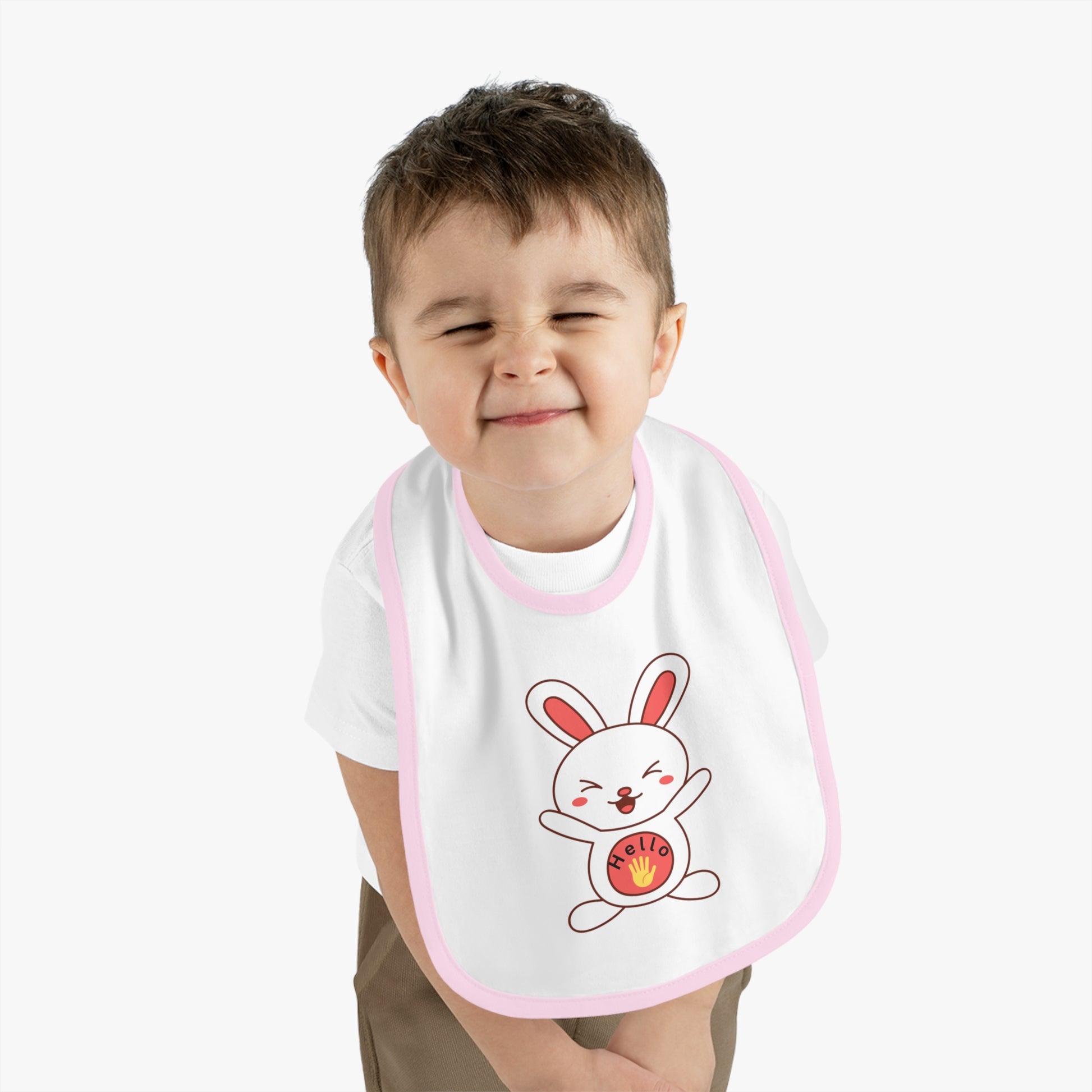 Child wearing a bib with a cartoon rabbit design on a plain background