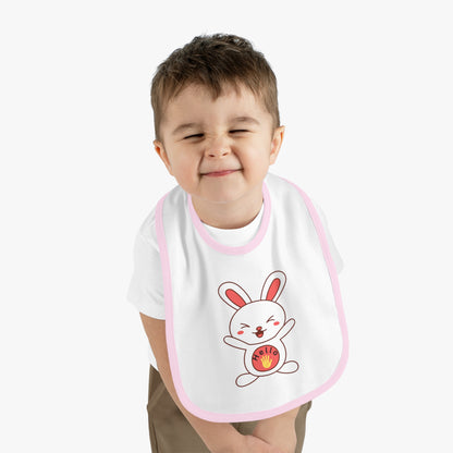 Child wearing a bib with a cartoon rabbit design on a plain background