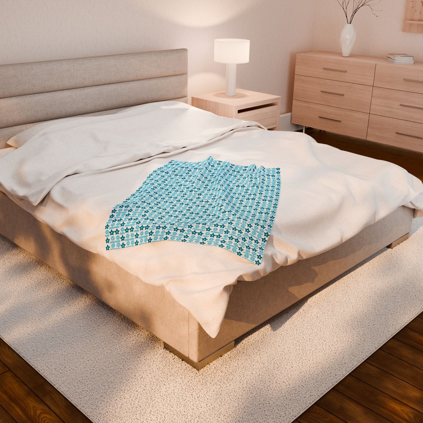 Bed with a blue patterned blanket in a bedroom setting