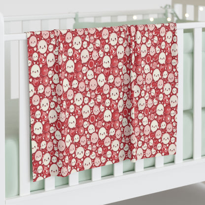 Baby crib with red and white patterned blanket