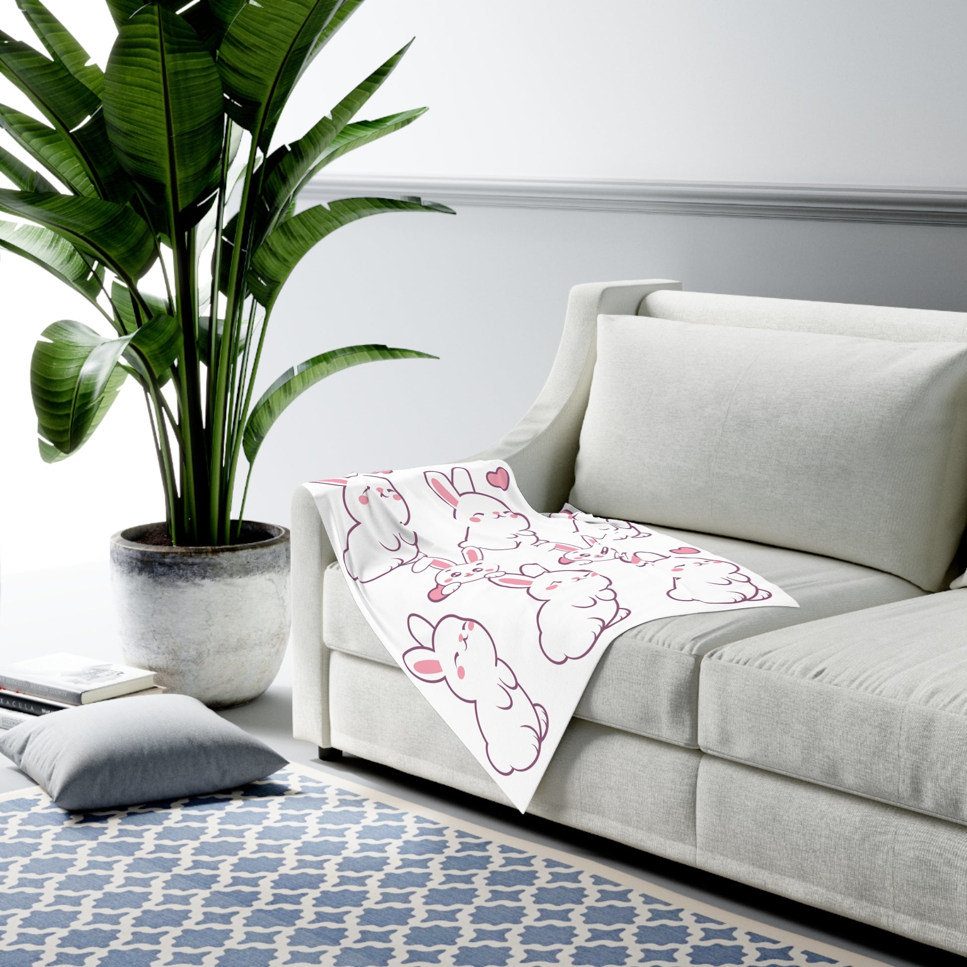 Sofa in a living room with a cartoon blanket and a potted plant.