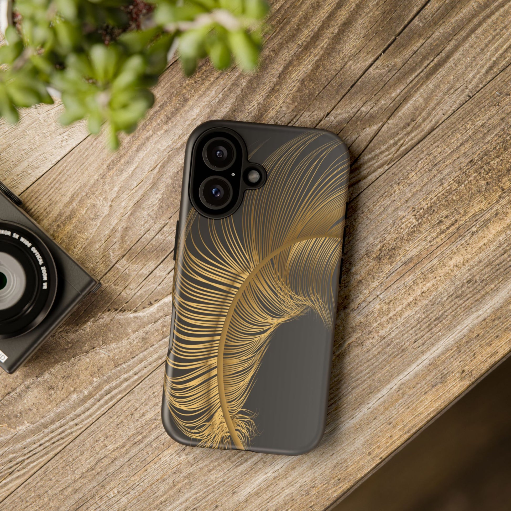 Phone case with gold feather design on black background