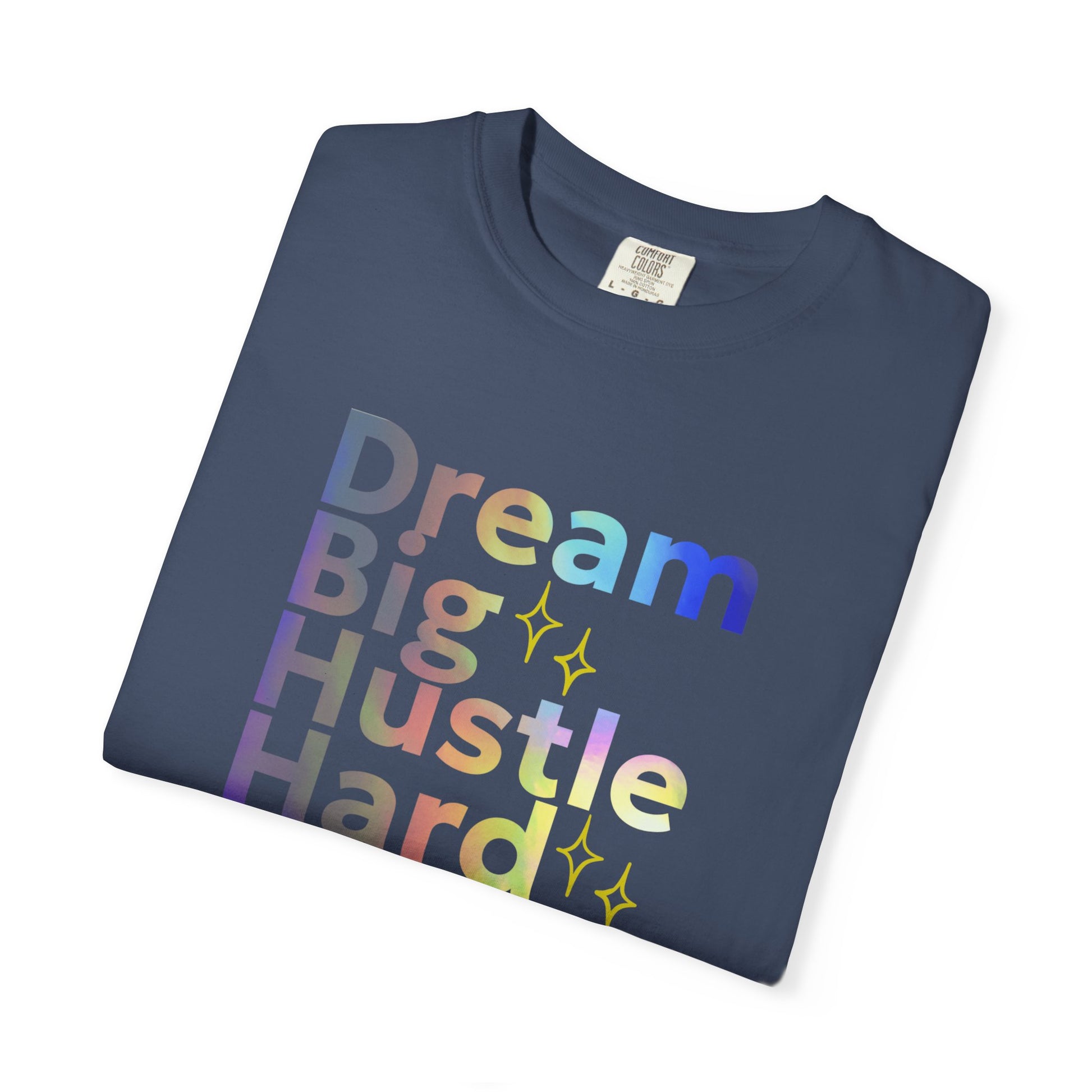Folded navy blue t-shirt with colorful text 'Dream Big Hustle Hard' on a white background