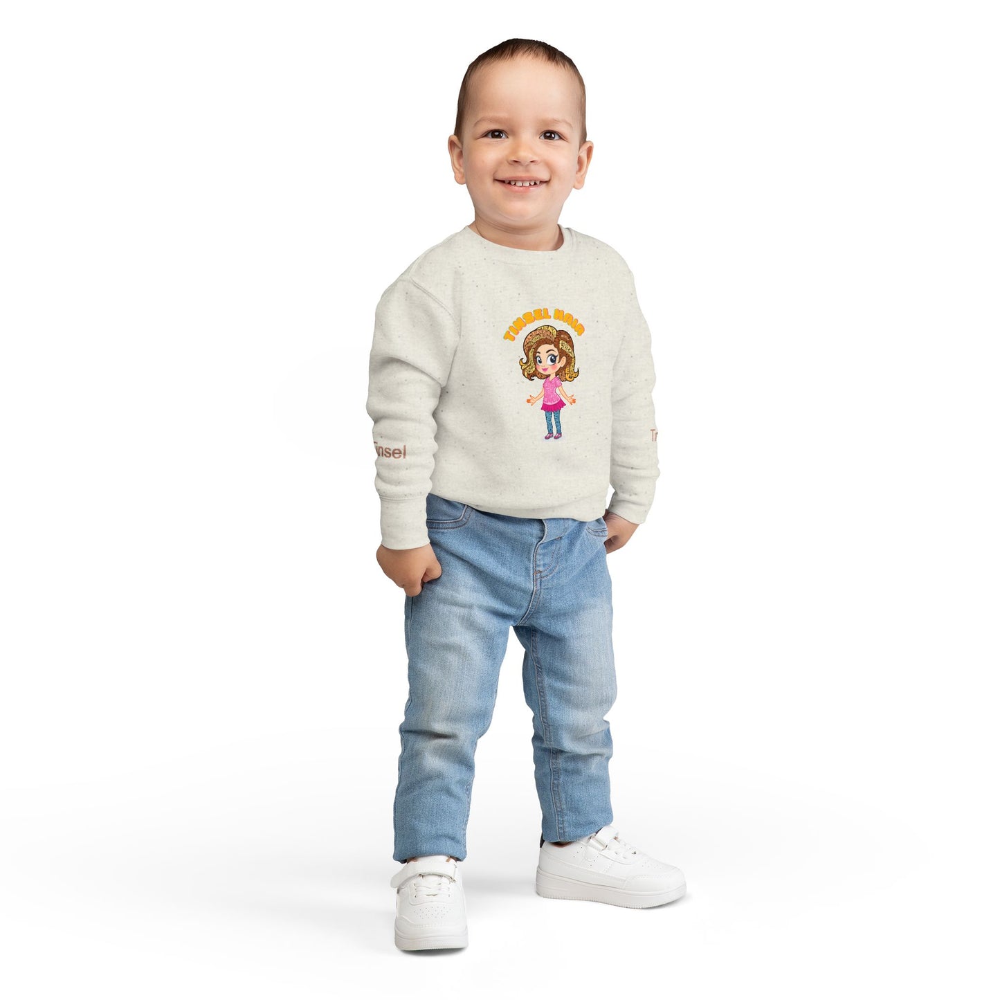 Child wearing a cream sweater with a design and blue jeans on a white background