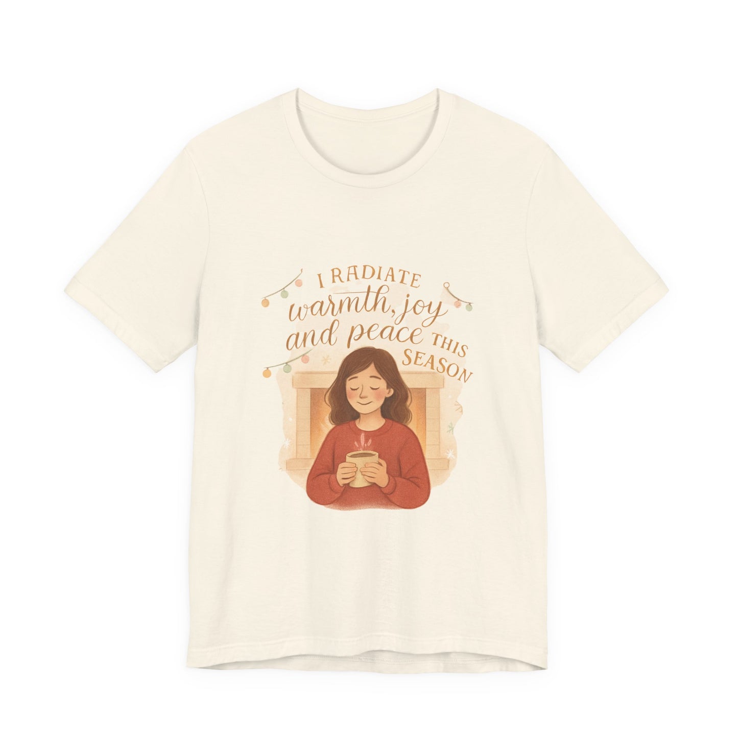 Beige t-shirt with a graphic of a person holding a mug and text 'I radiate warmth, joy, and peace this season' on a white background.