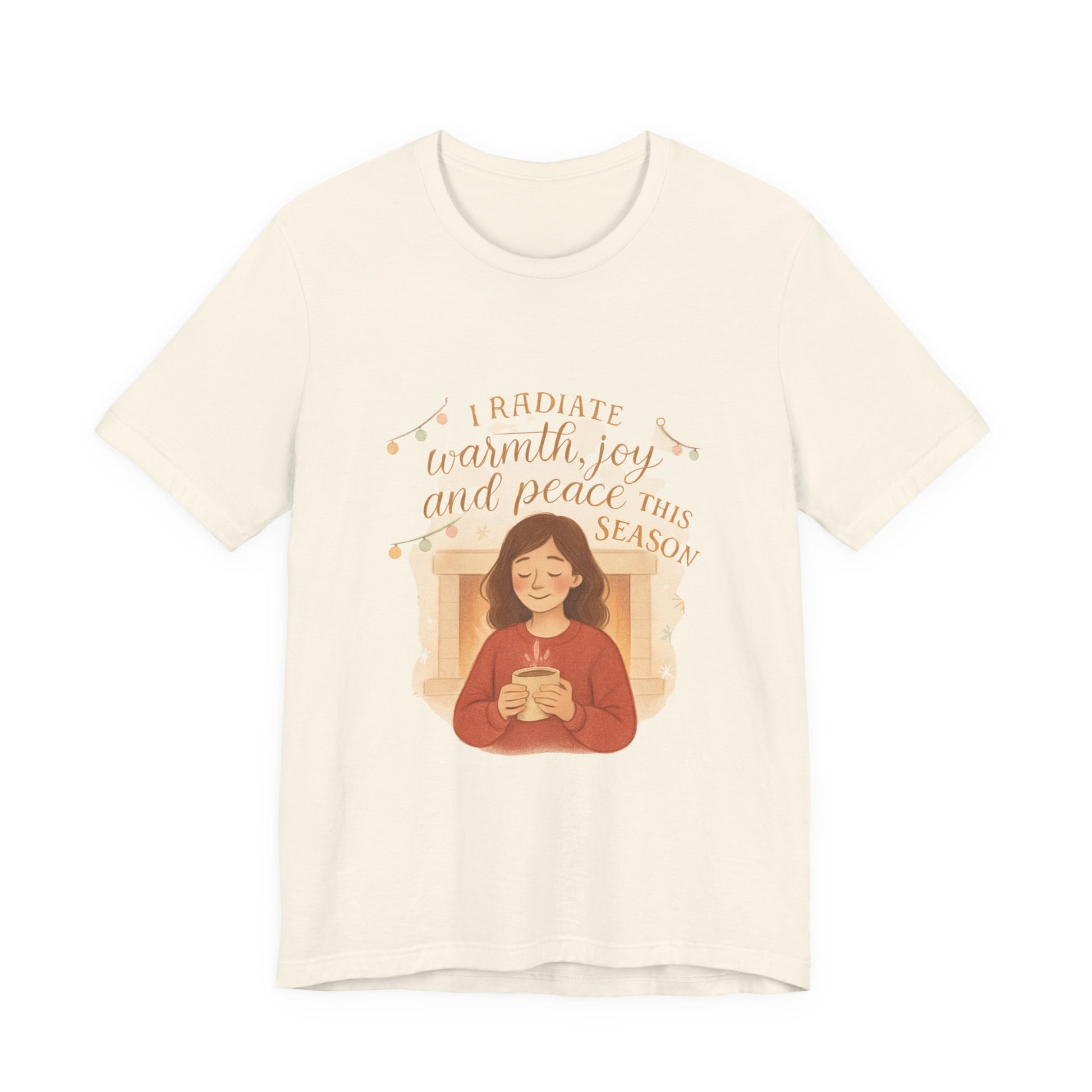 Beige t-shirt with a graphic of a person holding a mug and text 'I radiate warmth, joy, and peace this season' on a white background.