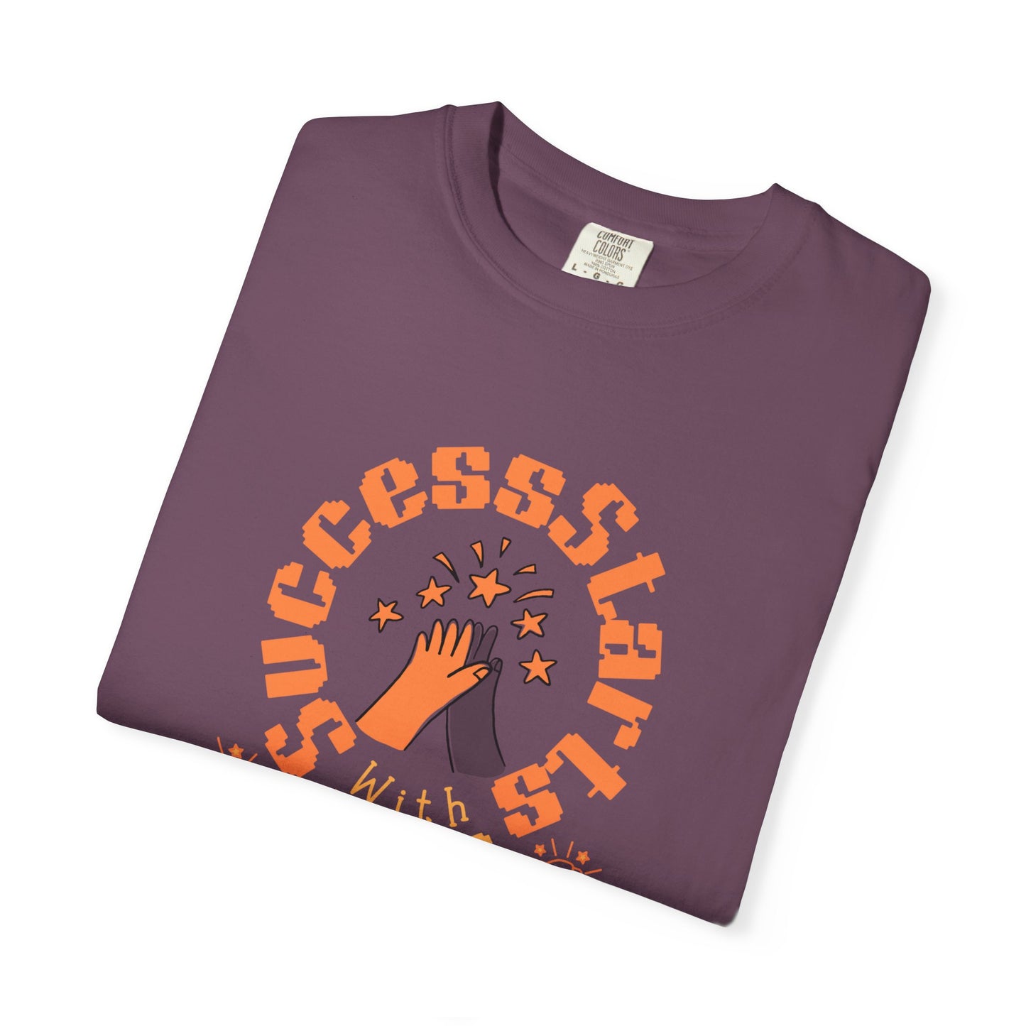 Folded purple t-shirt with orange 'SUCCESS STAR' design on a white background