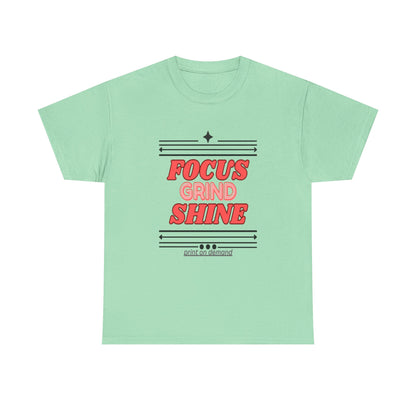 A  mint green unisex heavy cotton tee with the text 'FOCUS GRIND SHINE' printed on the front.