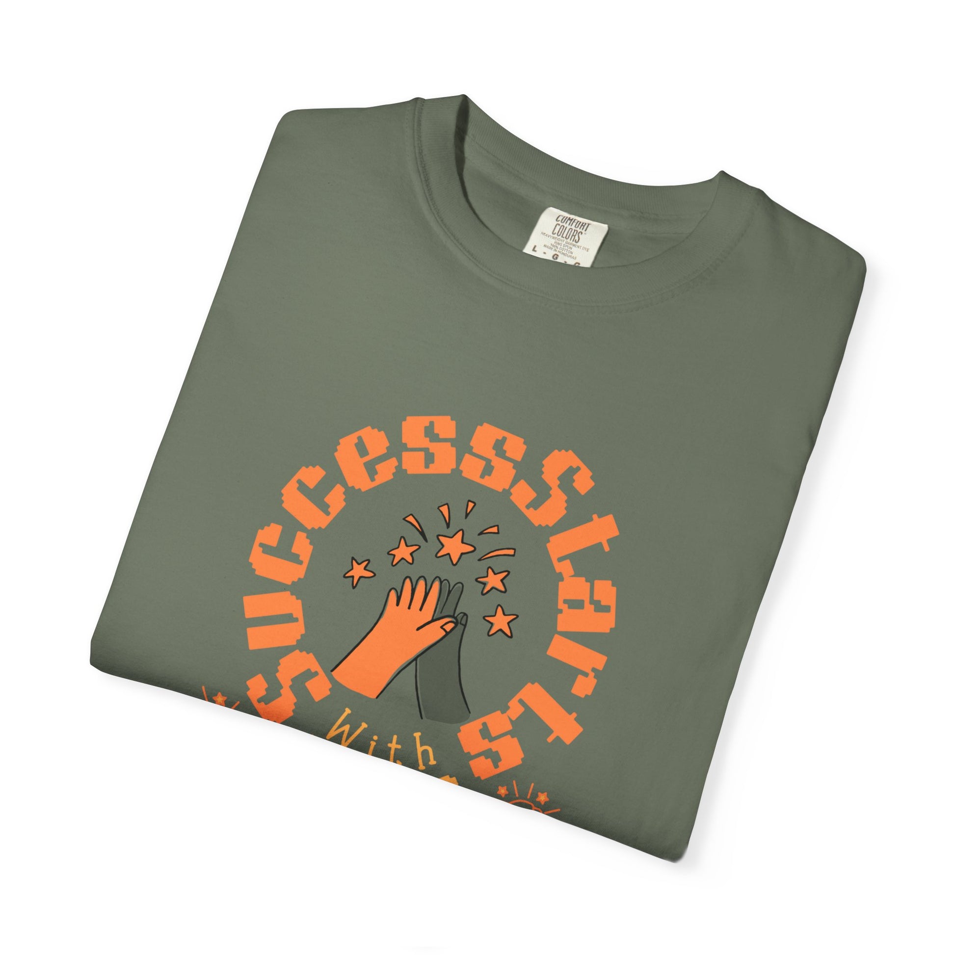 Folded green t-shirt with orange 'SUCCESSSTAR' graphic on a white background