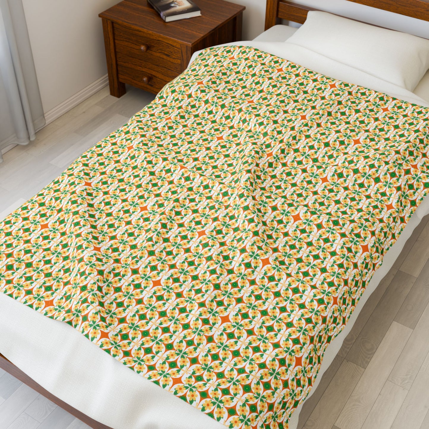 Bed with a patterned blanket in a room with a wooden nightstand.