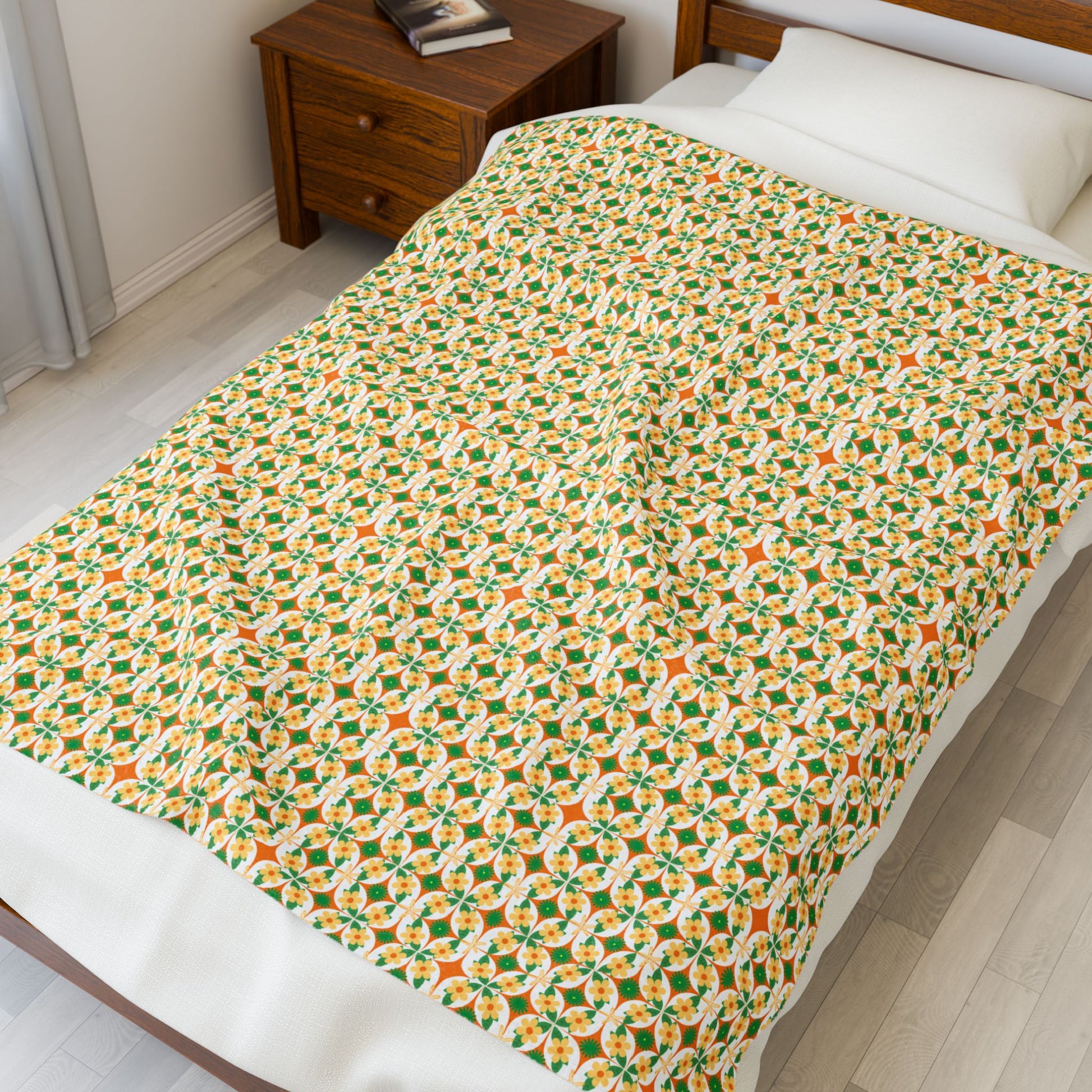 Bed with a patterned blanket in a room with a wooden nightstand.