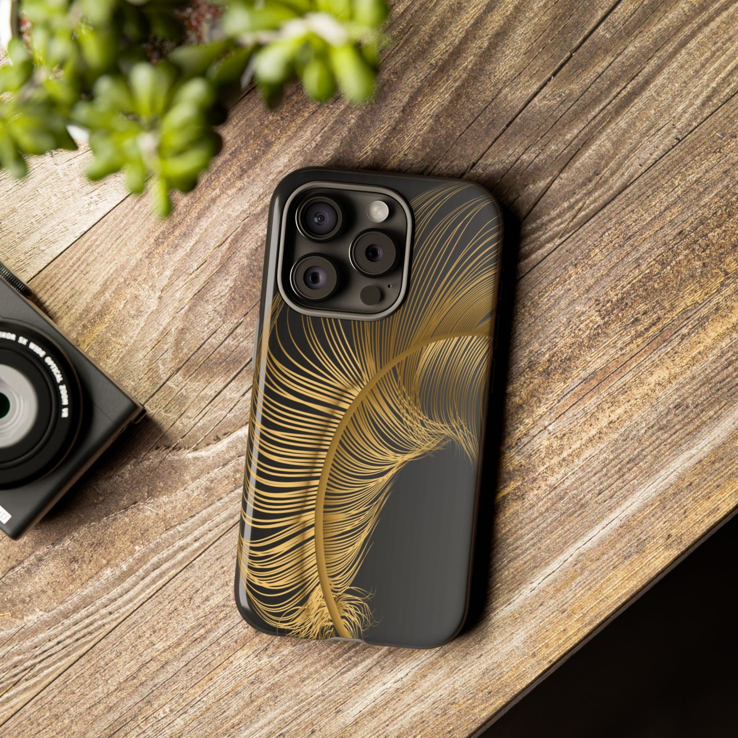 Phone case with gold feather design on black background