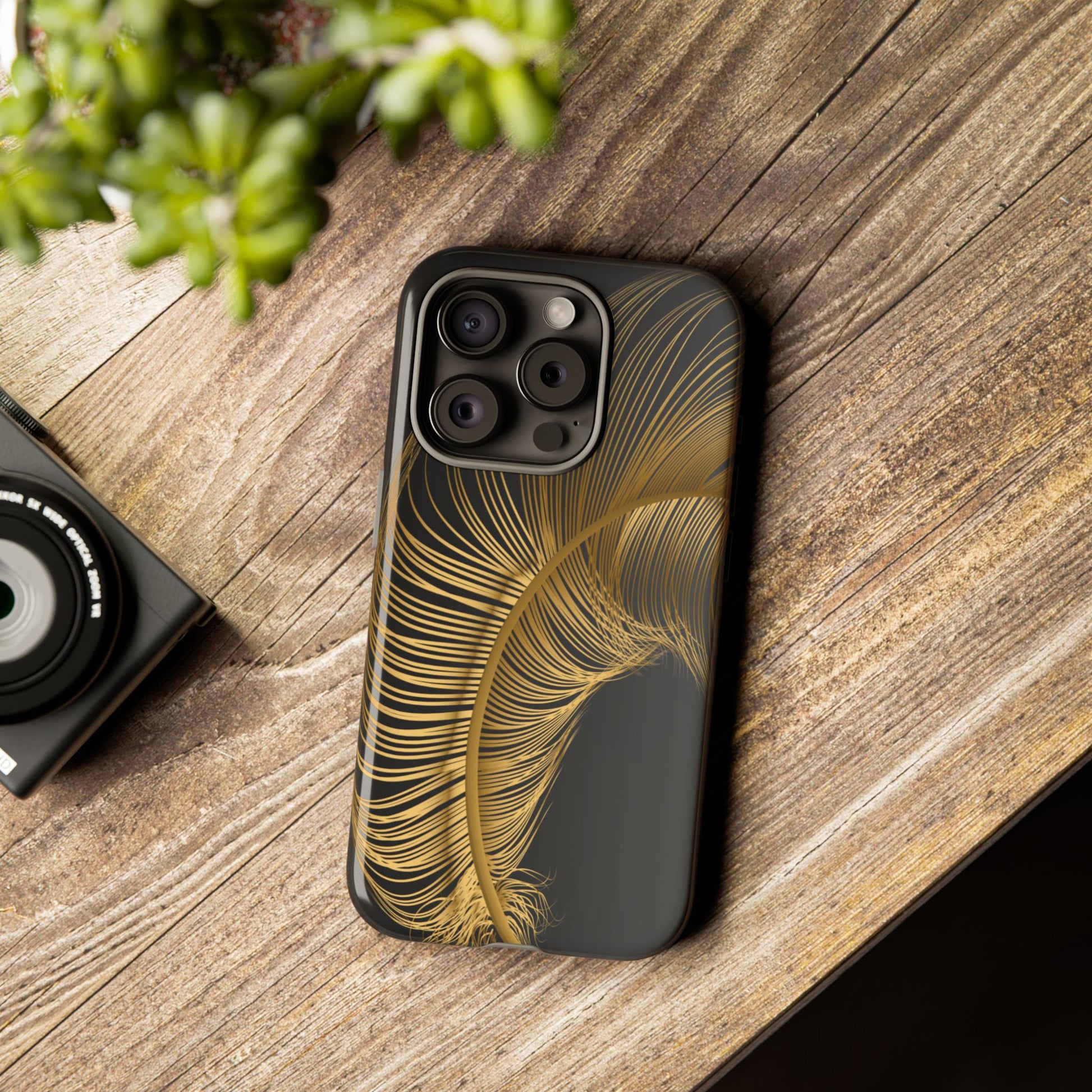 Phone case with gold feather design on black background