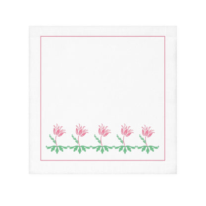 A white face towel with a printed floral design along the lower edge, in pink and green colors.