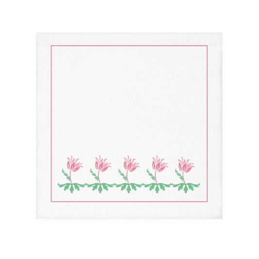 A white face towel with a printed floral design along the lower edge, in pink and green colors.