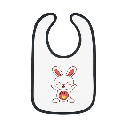 A white baby bib with black contrast trim and a centered graphic of a smiling cartoon rabbit holding a round object.