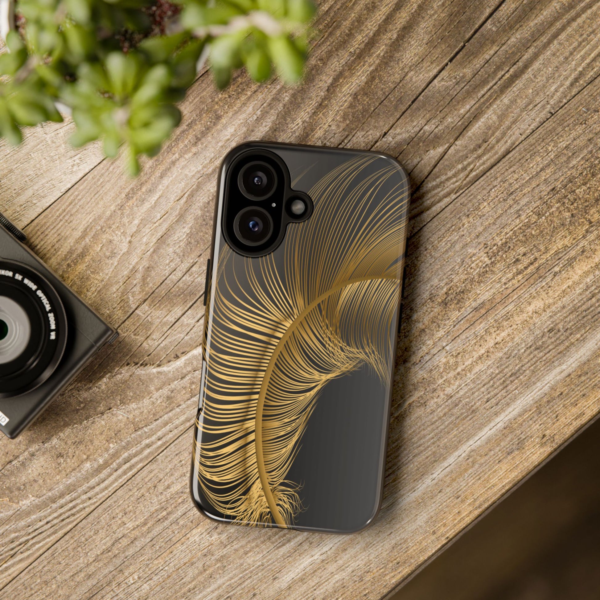 Phone case with gold feather design on black background