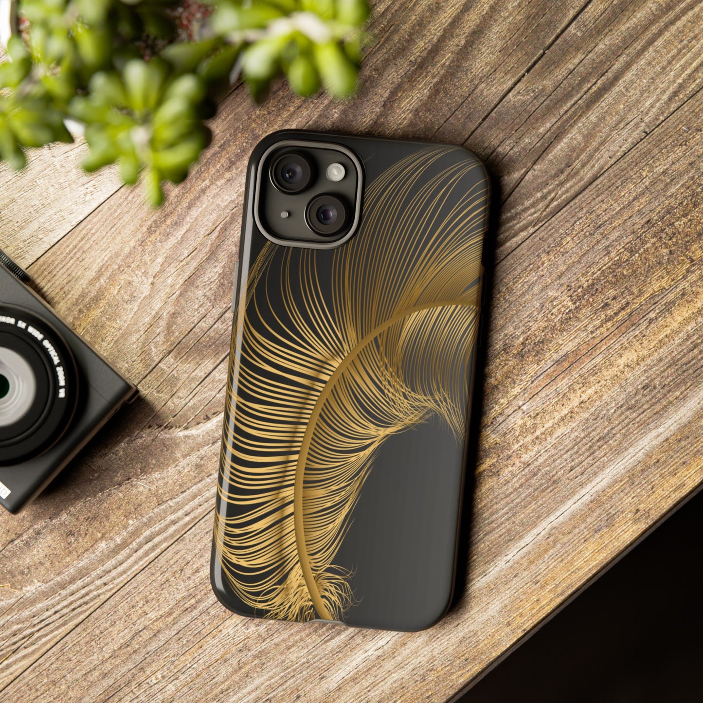 Phone case with gold feather design on black background
