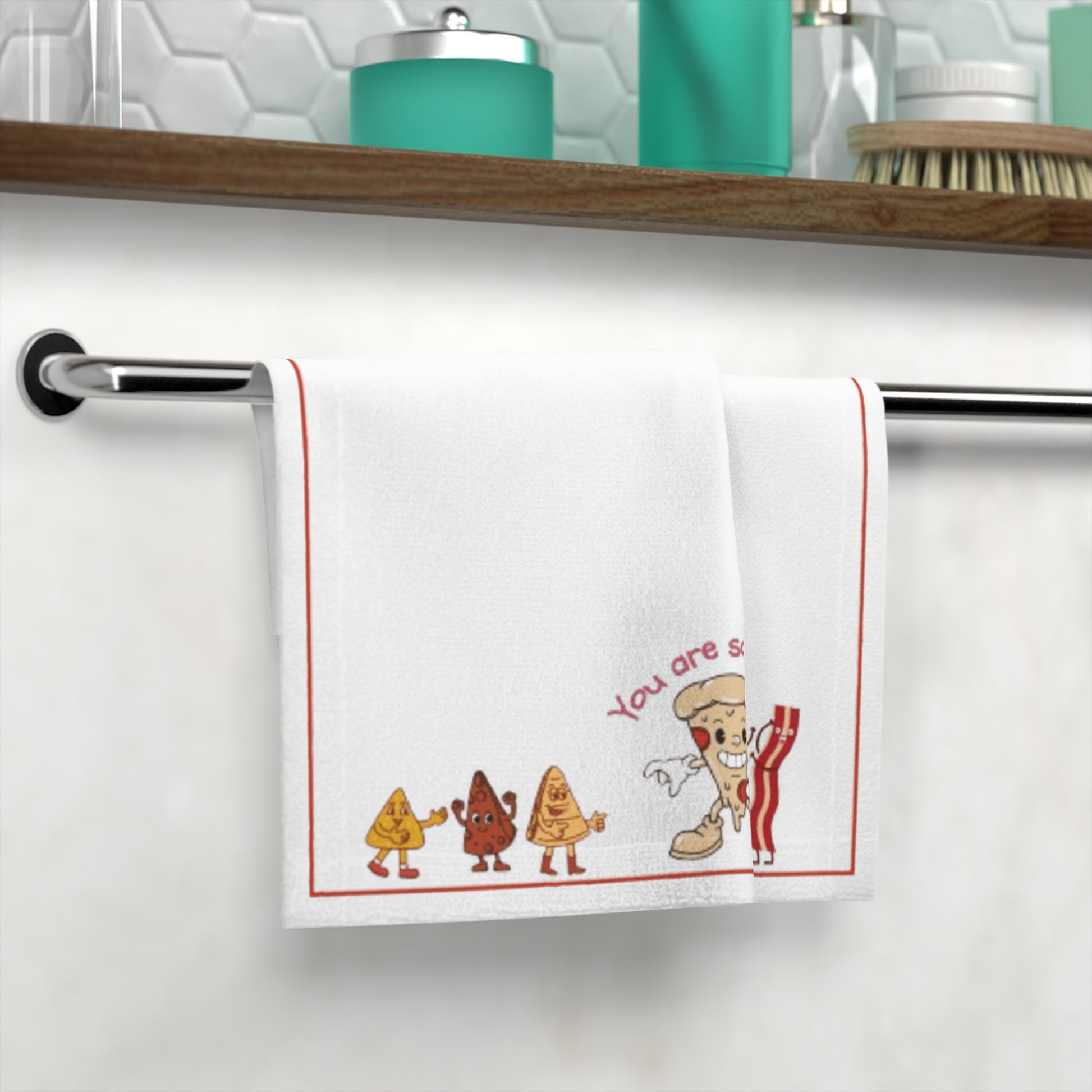 Decorative towel with cartoon characters and text hanging on a towel rack.