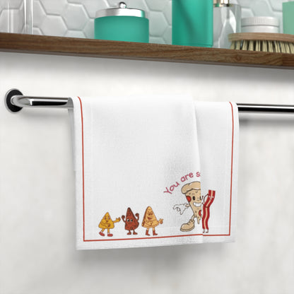 Decorative towel with cartoon characters and text hanging on a towel rack.