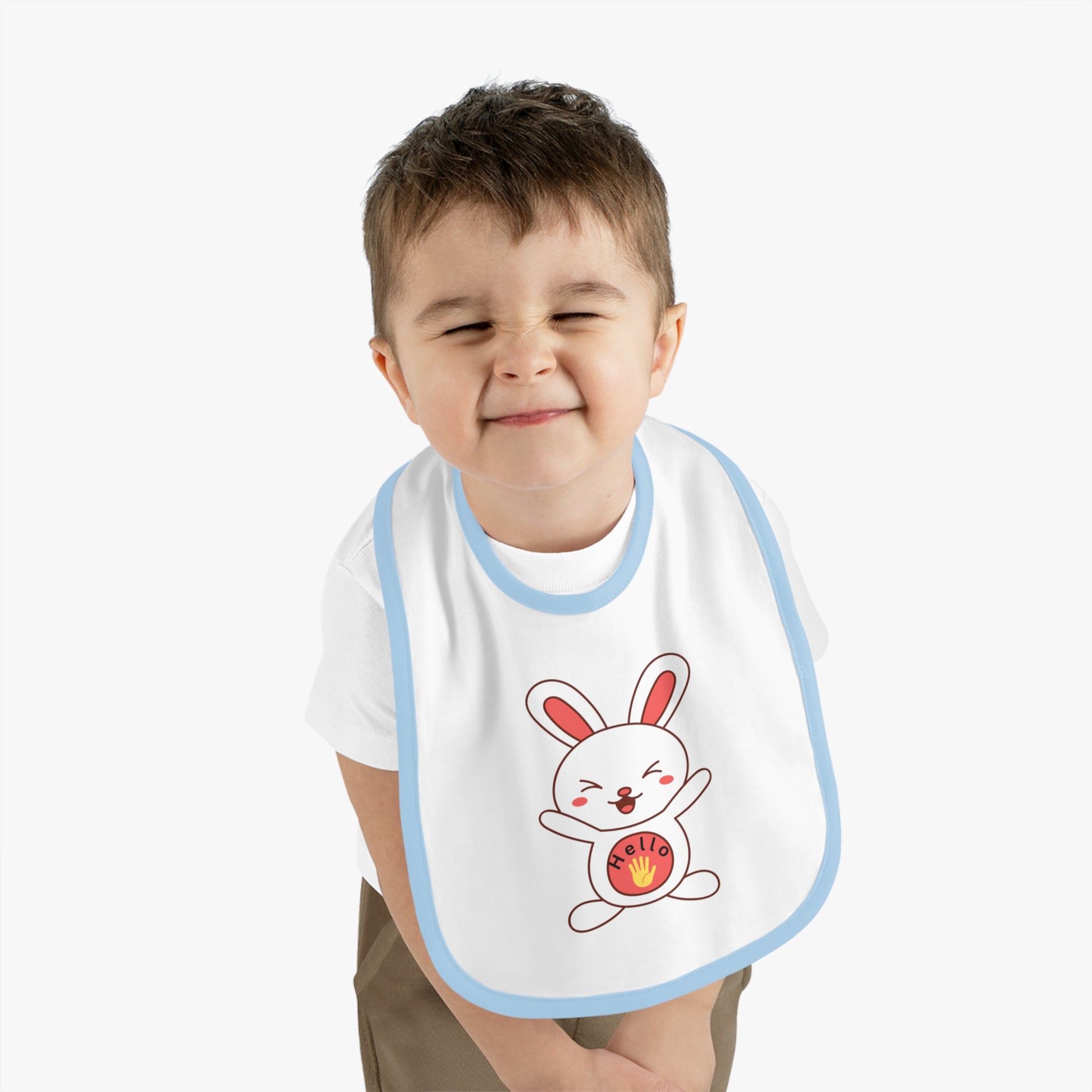 Child wearing a bib with a cartoon rabbit design on a plain background