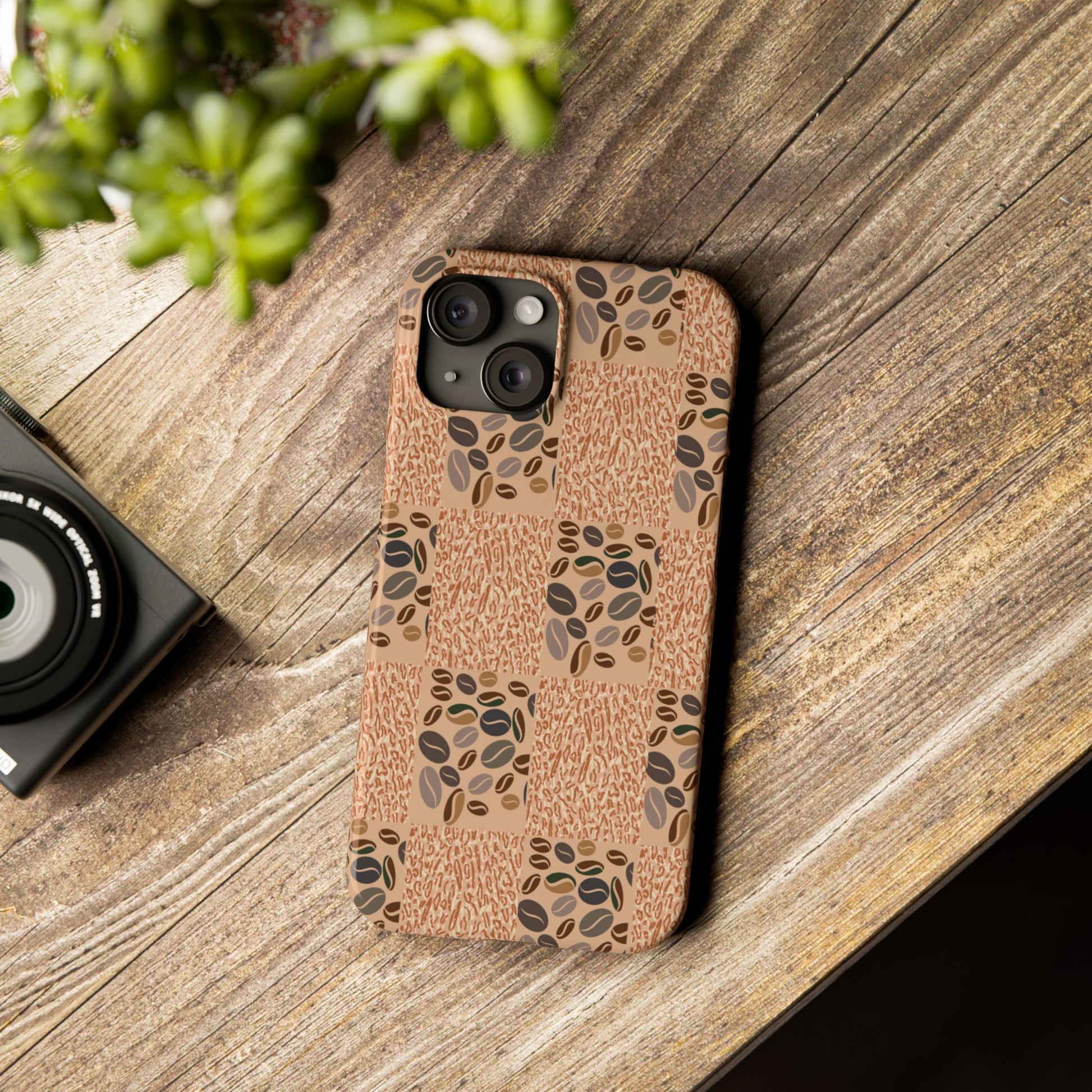 Phone case with coffee bean pattern on wooden surface.