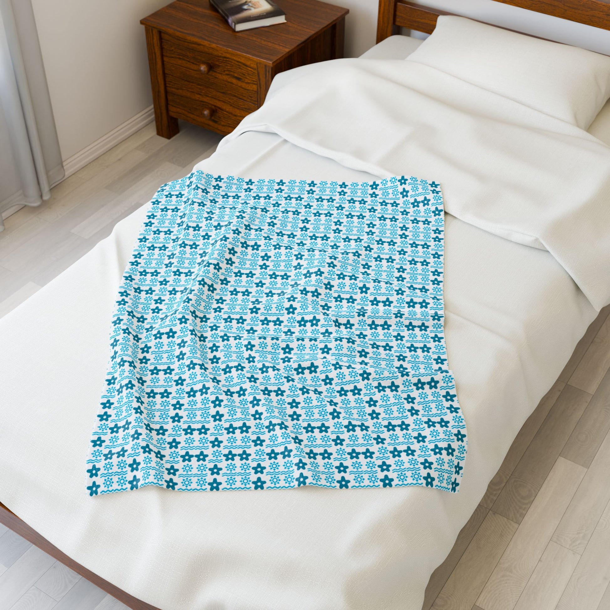 Blue patterned blanket on a bed in a bedroom.