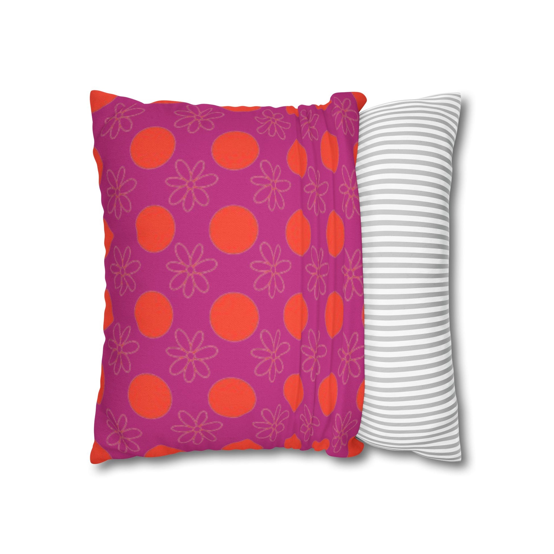 pillow with patterned covers, one pink with red circles and floral designs, the other white with gray stripes, on a white background.