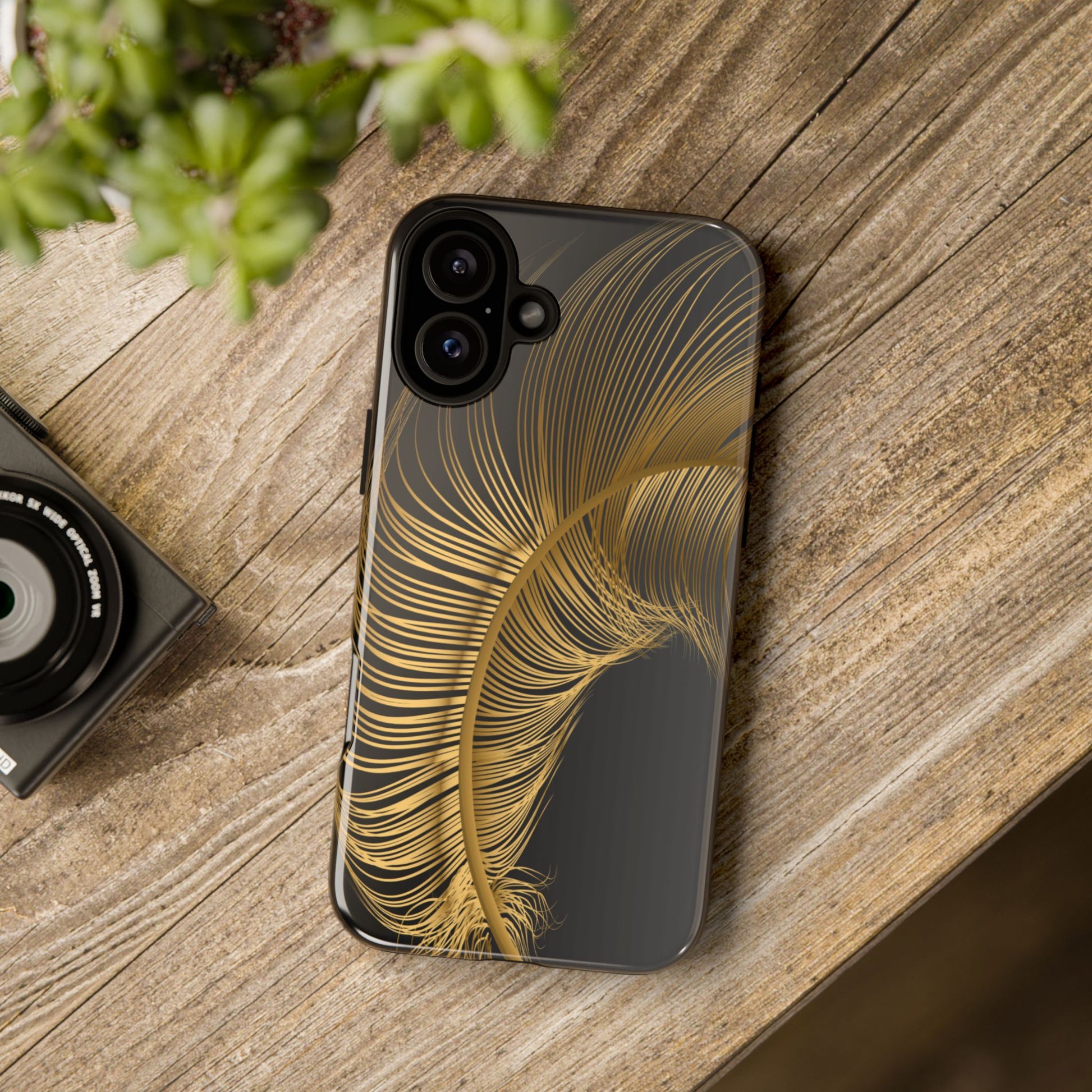 Phone case with gold feather design on black background
