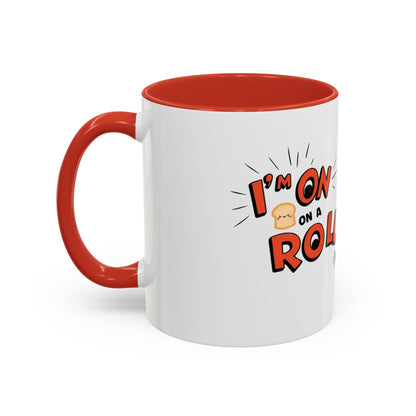 A white ceramic coffee mug with a red interior, featuring an illustration of a bread character with the words 'on a roll' and a smiling face.