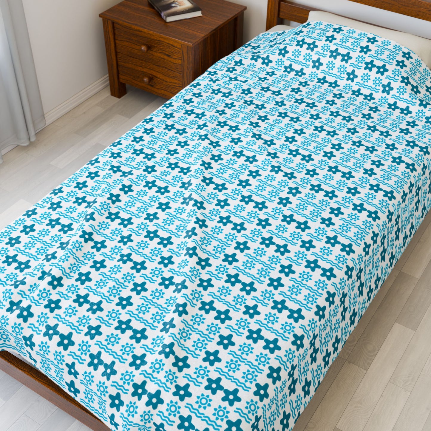 Bed with blue and white patterned bedspread in a bedroom.